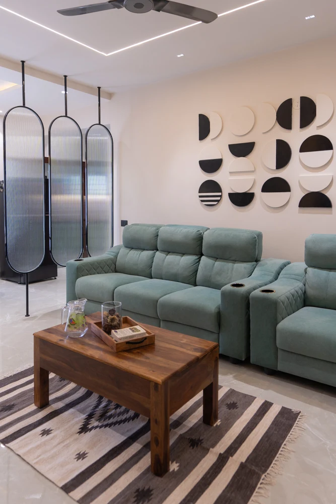 Sage green seating, patterned rug and sculptural wall details in a living room